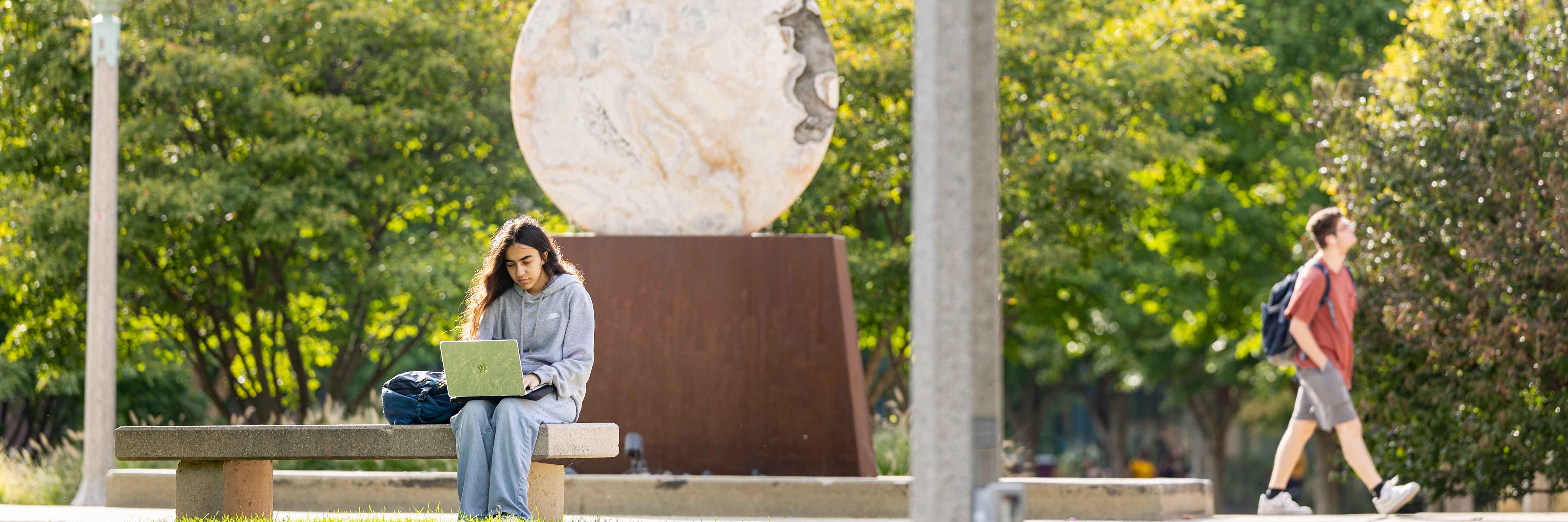 A student studying at Lakeshore campus outside.